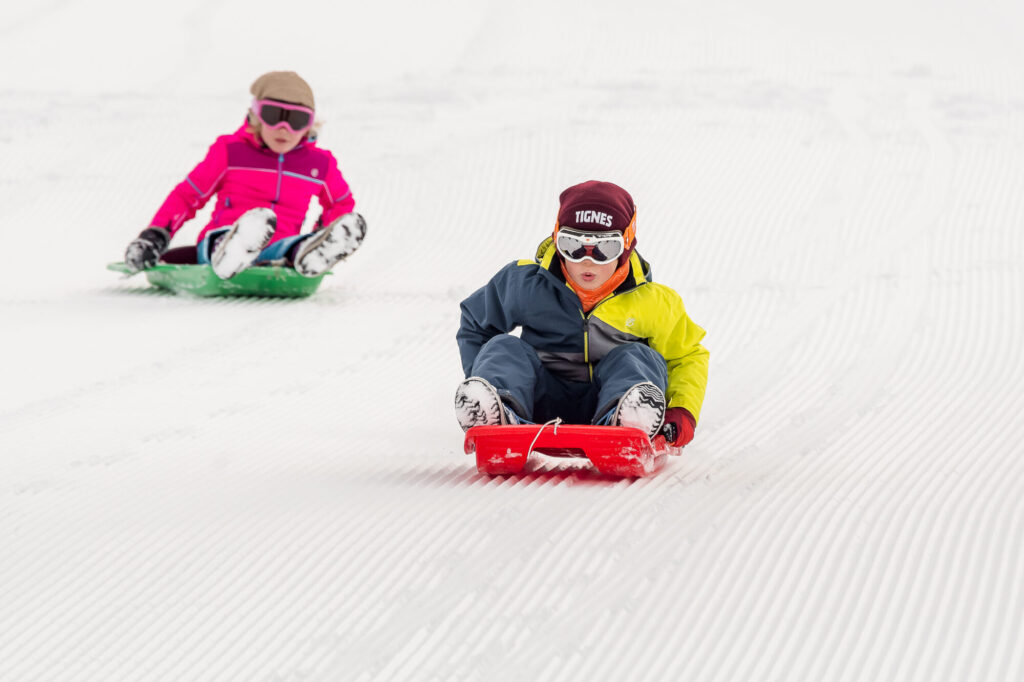 Children enjoying sledging on the snow in Tignes. © Andy Parant
