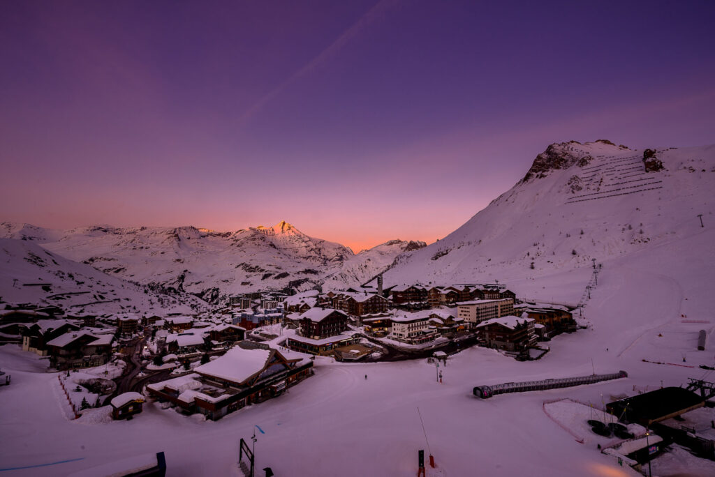 Tignes beneath snow-covered mountains and a colourful winter sky. © Andy Parant