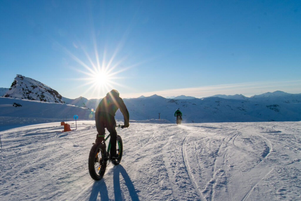 Fat biker riding across the snow as the sun sets over Val Thorens. © T. Loubere – OT Val Thorens