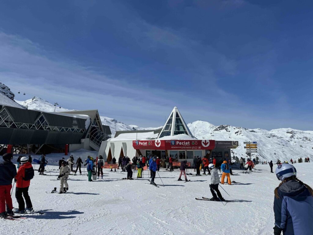 Skiers and mountain buildings on the snow-covered slopes of Val Thorens