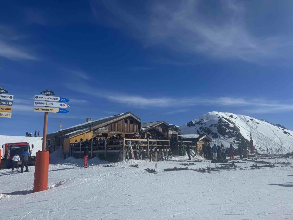 Ski slopes and mountain restaurant beneath blue skies in Val Thorens