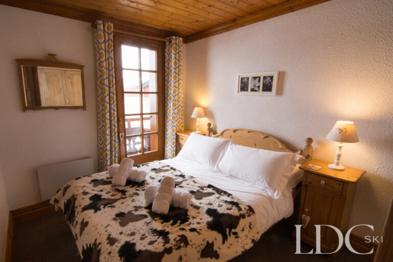 Double bedroom with traditional wooden furnishings at Violette in St Martin de Belleville