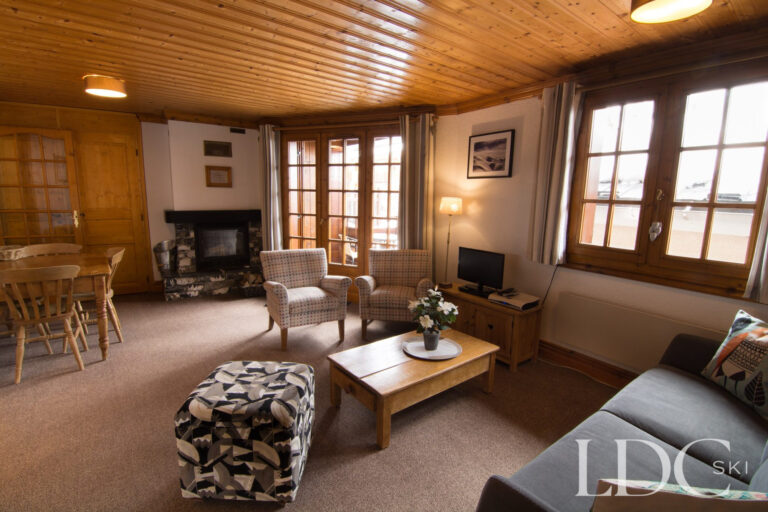 Comfortable open-plan lounge and dining area with fireplace at Violette in St Martin de Belleville